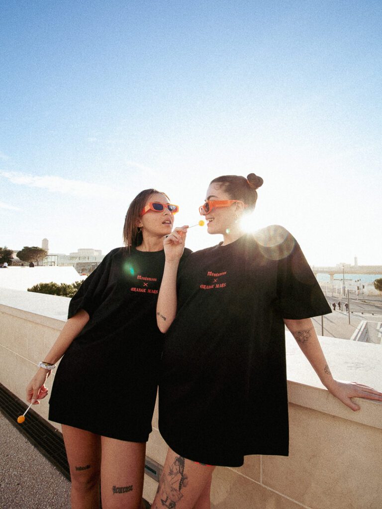 Photographie de deux modèles féminins qui portent un t-shirt de la marque Orange mars par John Bertolini