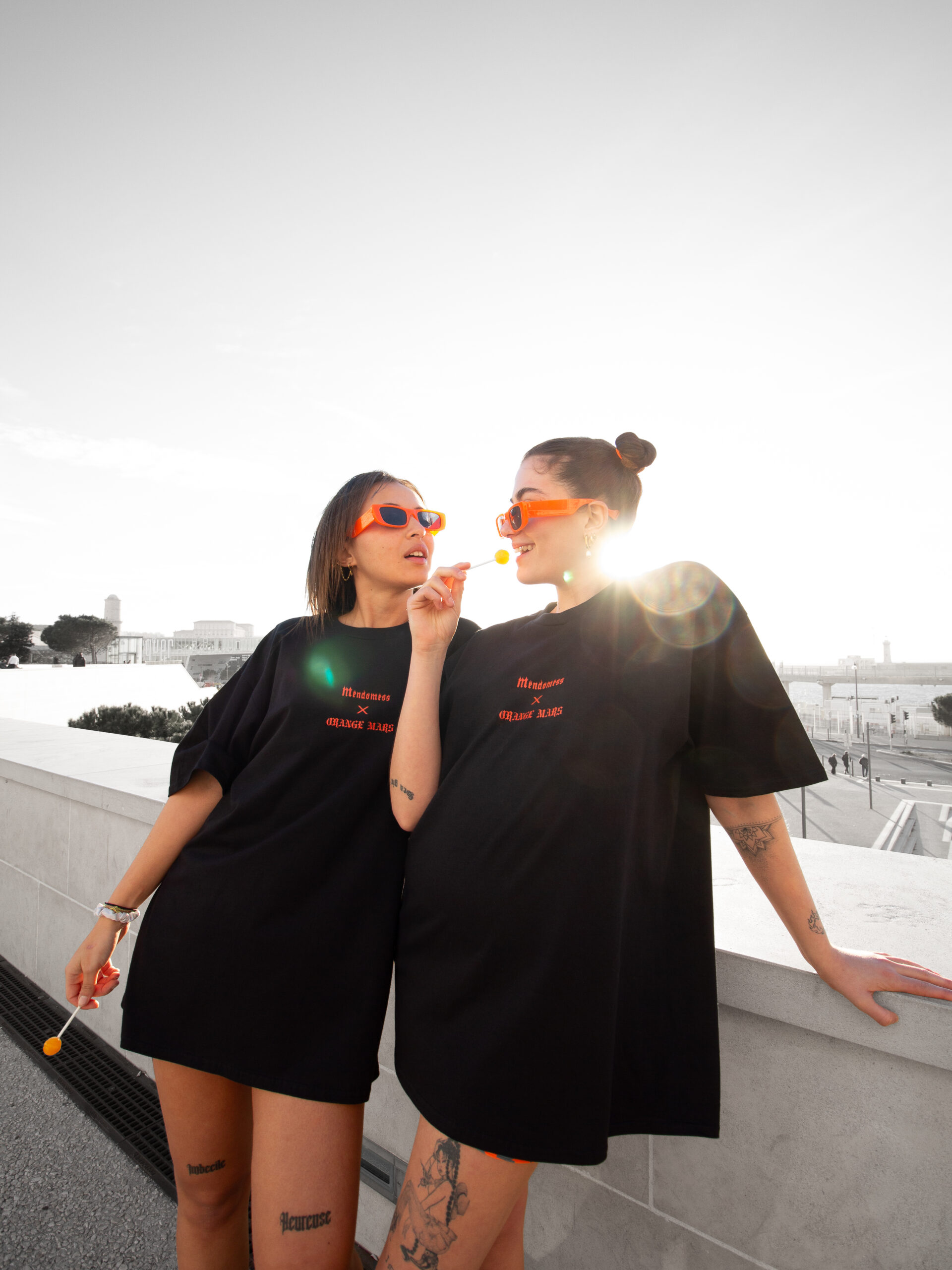 Photographie de deux modèles féminins qui portent un t-shirt de la marque Orange mars par John Bertolini