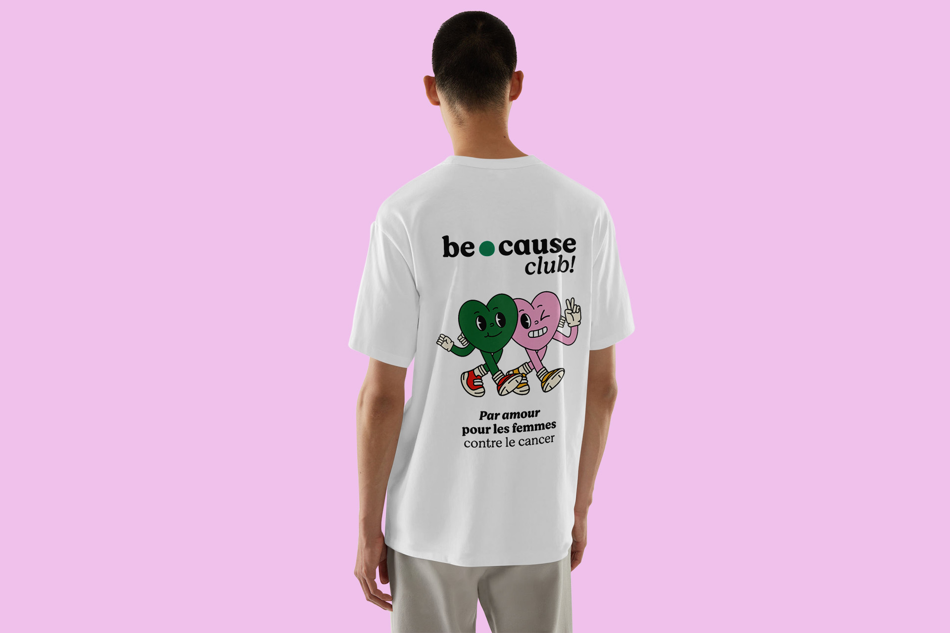 Photographie d'un modèle debout de dos qui porte le tshirt de because club sur un fond rose